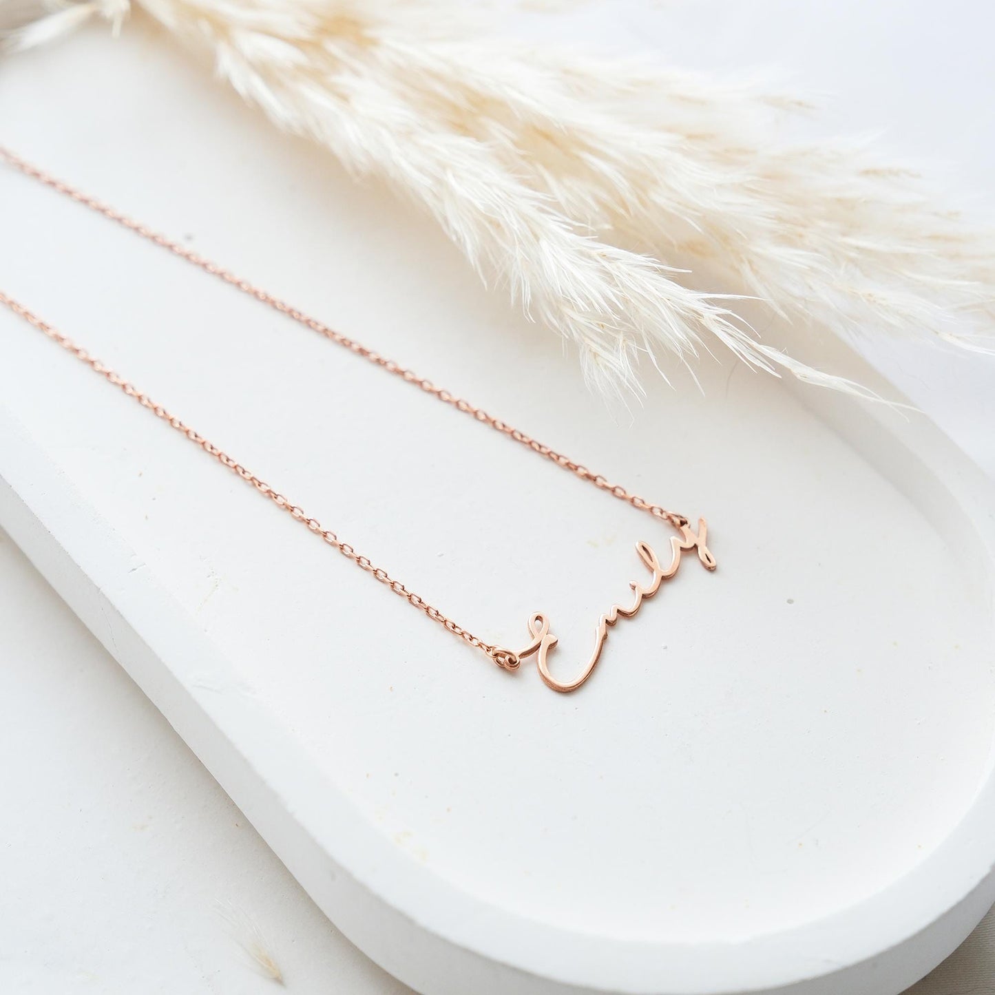 Present your loved ones with a unique gift through our customizable name necklaces. Available in gold, silver, and rose gold plating, these elegant and durable designs perfectly complement personal style. Add your name, and leave a lasting impression