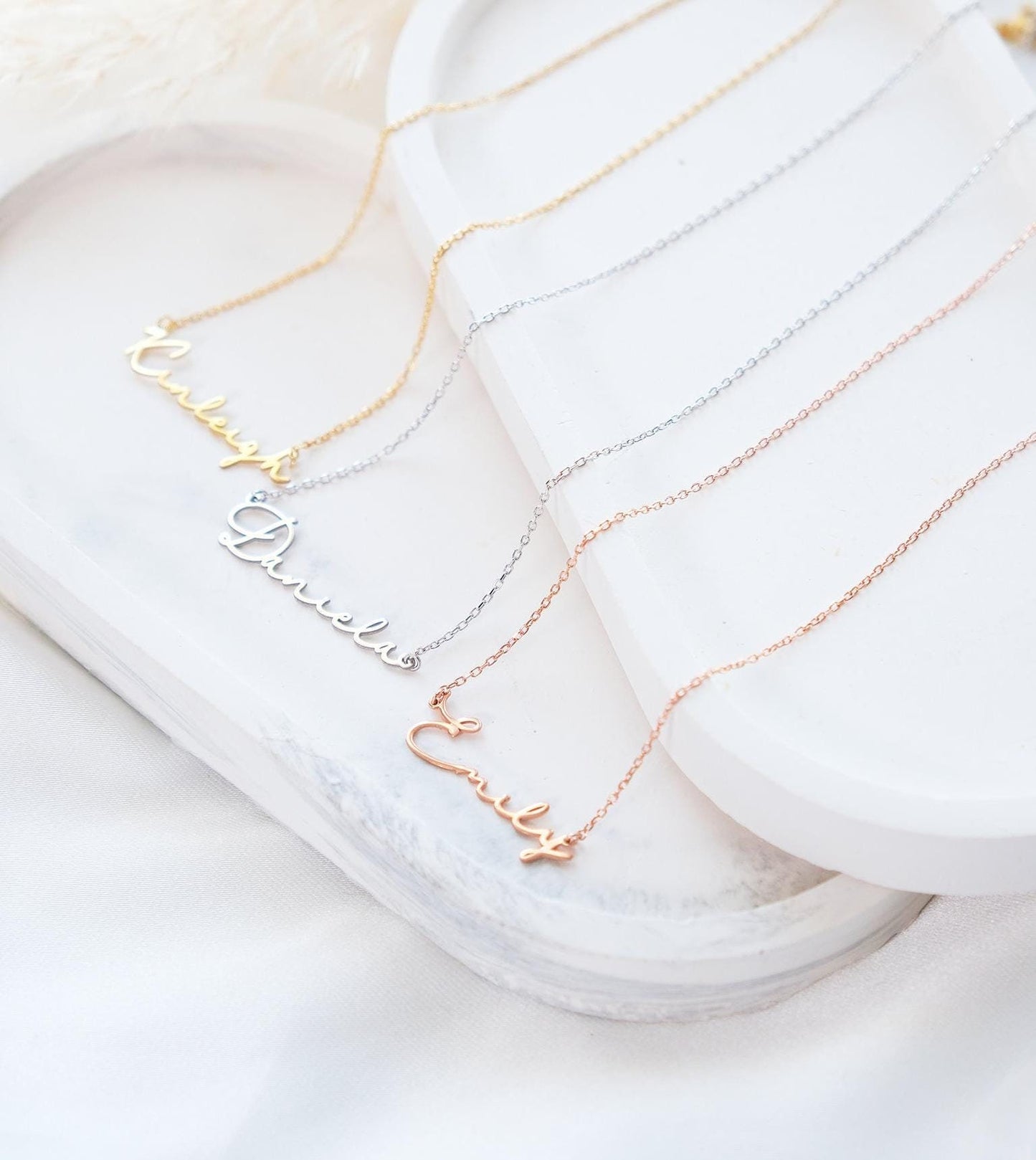 Present your loved ones with a unique gift through our customizable name necklaces. Available in gold, silver, and rose gold plating, these elegant and durable designs perfectly complement personal style. Add your name, and leave a lasting impression