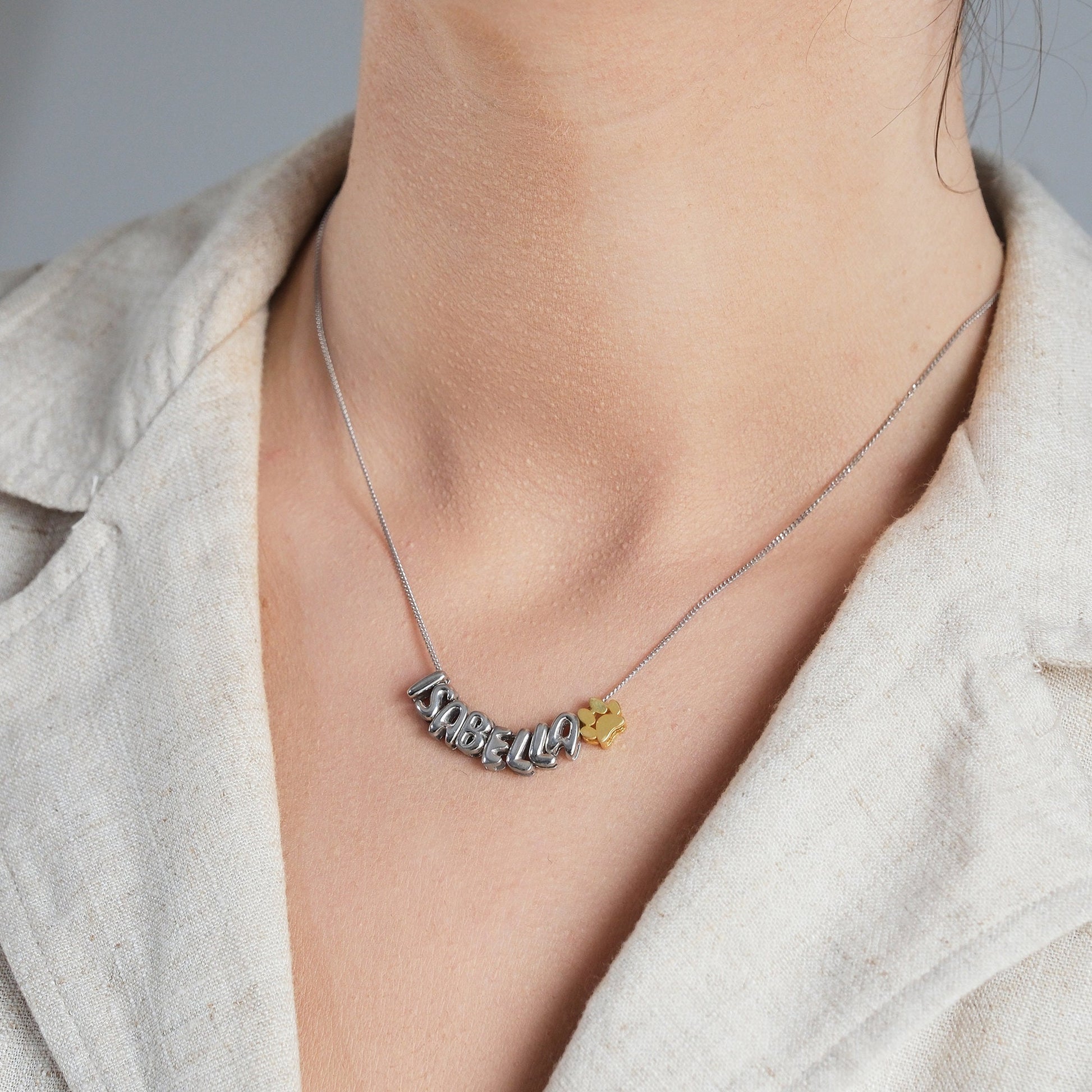 Discover our Paw Print and Balloon Necklaces perfect for personalizing with a name The playful paw print and whimsical balloon shapes add a unique touch while customizable engraving makes these pieces truly special Available in gold silver rose gold