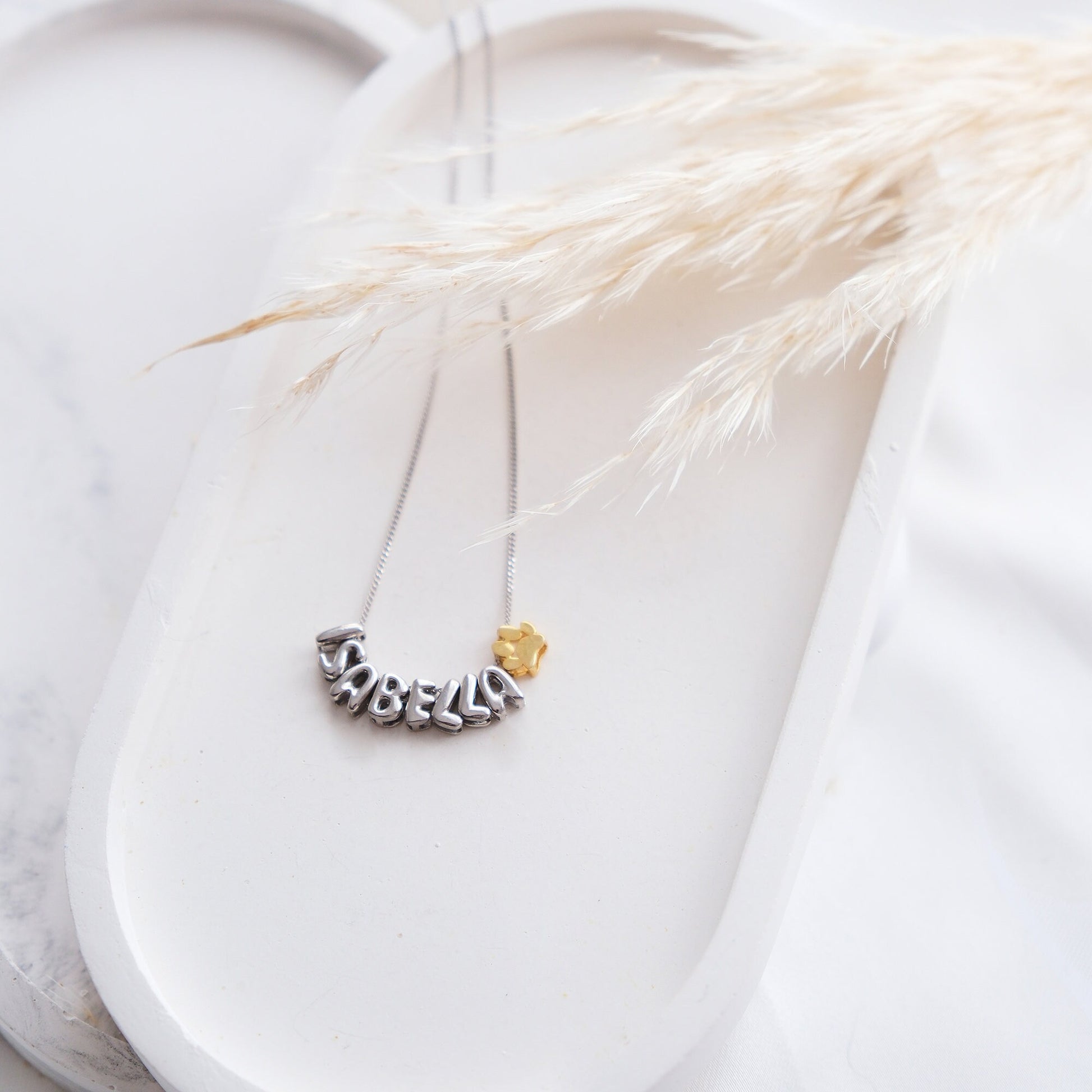 Discover our Paw Print and Balloon Necklaces perfect for personalizing with a name The playful paw print and whimsical balloon shapes add a unique touch while customizable engraving makes these pieces truly special Available in gold silver rose gold