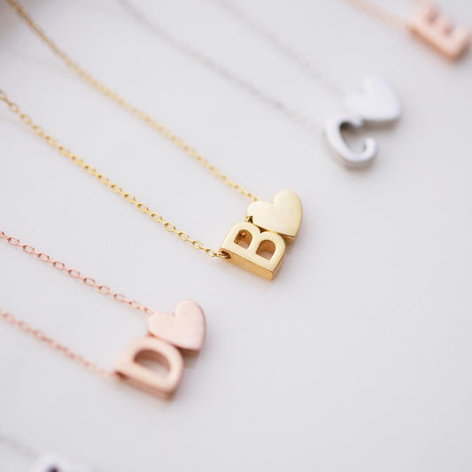Make a bold statement with our Block Letters Necklace, featuring a heart for a touch of love. Personalize it with your name or a meaningful word. Available in gold, silver, and rose gold this piece adds a modern stylish and personal touch to any look