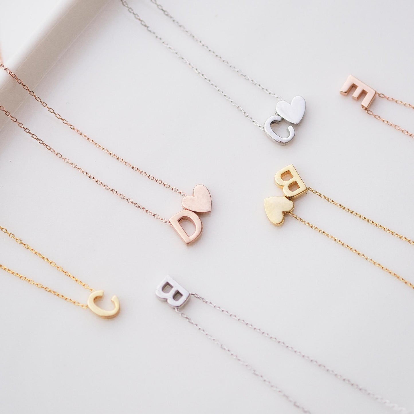 Make a bold statement with our Block Letters Necklace, featuring a heart for a touch of love. Personalize it with your name or a meaningful word. Available in gold, silver, and rose gold this piece adds a modern stylish and personal touch to any look