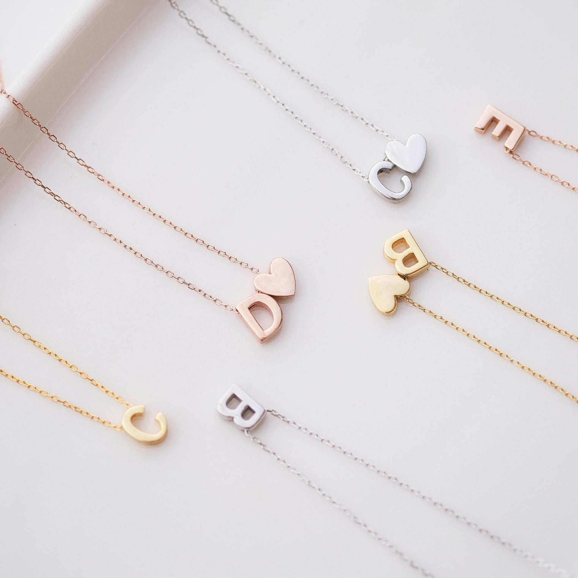 Make a bold statement with our Block Letters Necklace, featuring a heart for a touch of love. Personalize it with your name or a meaningful word. Available in gold, silver, and rose gold this piece adds a modern stylish and personal touch to any look