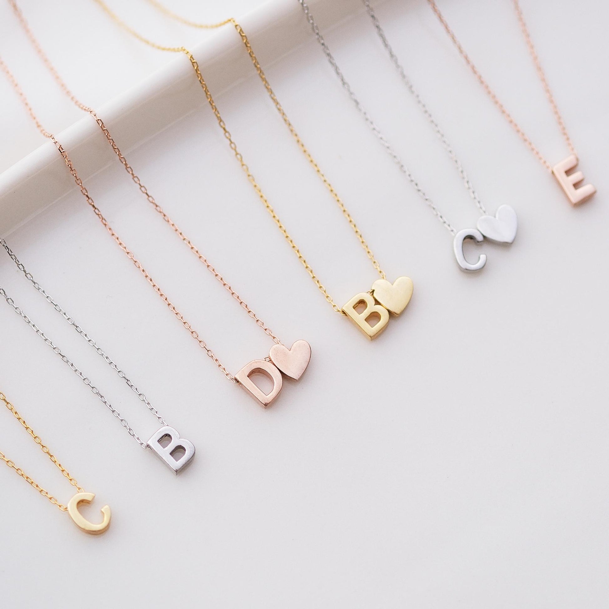 Make a bold statement with our Block Letters Necklace, featuring a heart for a touch of love. Personalize it with your name or a meaningful word. Available in gold, silver, and rose gold this piece adds a modern stylish and personal touch to any look