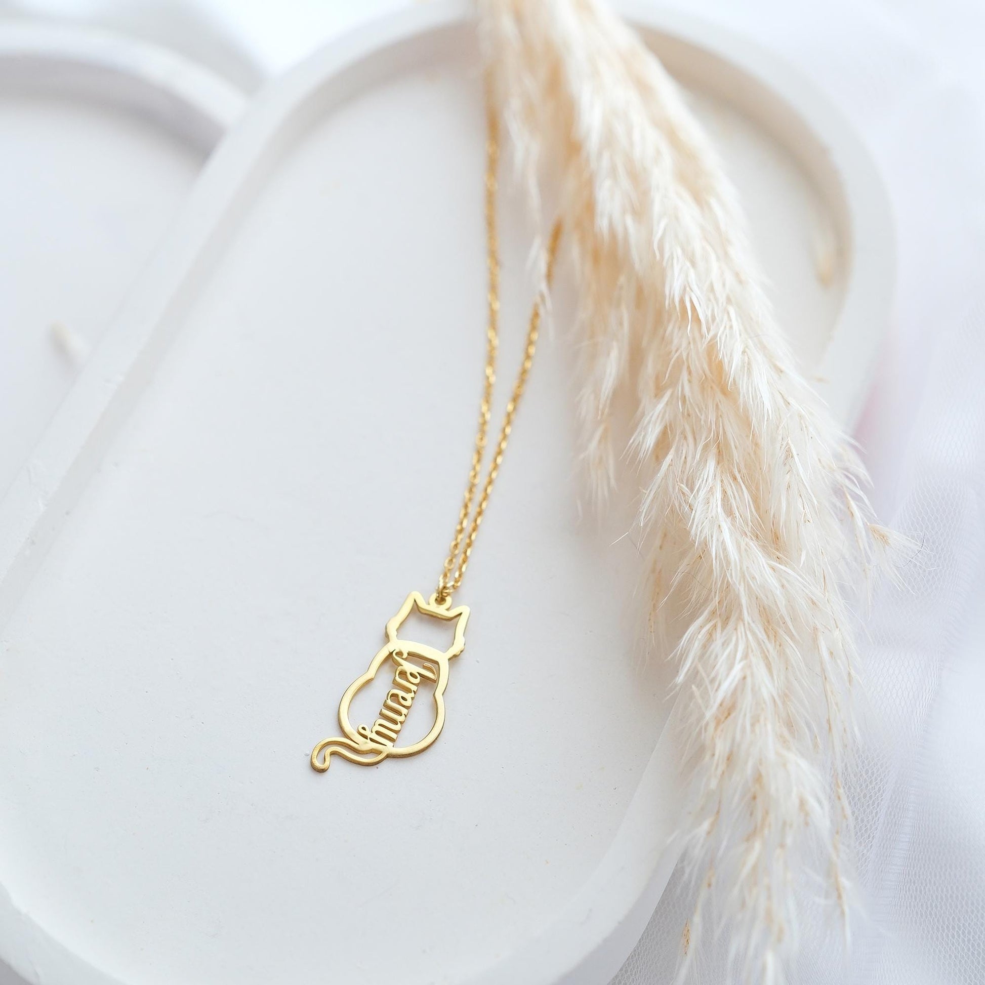 The Cat-Shaped Necklace is a stylish, playful piece perfect for cat lovers. It features a charming cat silhouette that can be personalized with a name of your choice. Available in silver, gold, and rose gold, this unique accessory adds a personal