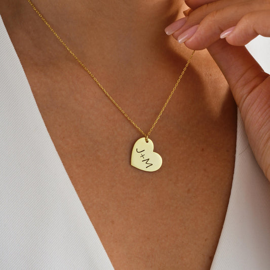 Celebrate your connection with this custom heart-shaped pendant, engraved with your chosen initials. Whether it’s your partner, child, or best friend – this simple and meaningful necklace is designed to keep your bond close every day.
Material: 925K Sterling Silver / 14K Solid Gold  
Pendant: Heart-shaped plate engraved with up to 2 initials (e.g. J+M)  
• Chain Length: Adjustable (16&quot; + 2&quot; extender)  
Anniversary – Couples – Friendship – Family initials – Sentimental gifts – Everyday wear