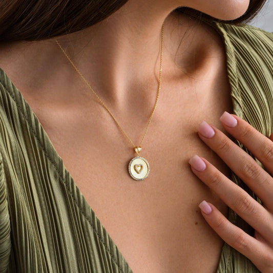✨A stunning fluted round medallion necklace featuring a sparkling CZ heart in the center, surrounded by shimmering stones for extra brilliance. A romantic and elegant piece perfect for gifting or treating yourself.